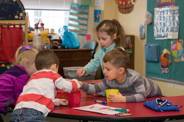 Preschool students work together at a table