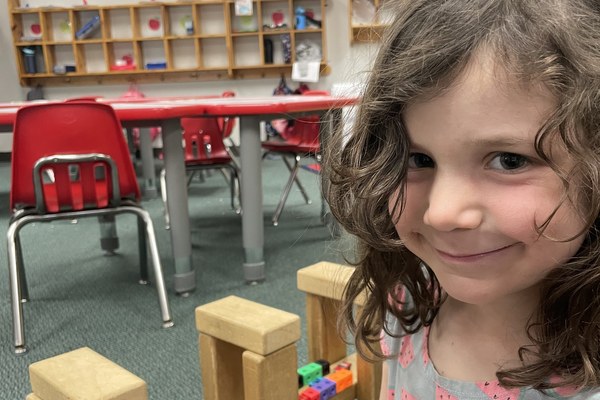 A preschool student plays with a bead maze